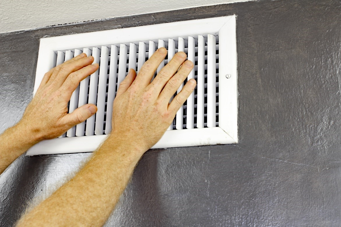 Technician trying to remove air conditioning vent from the wall